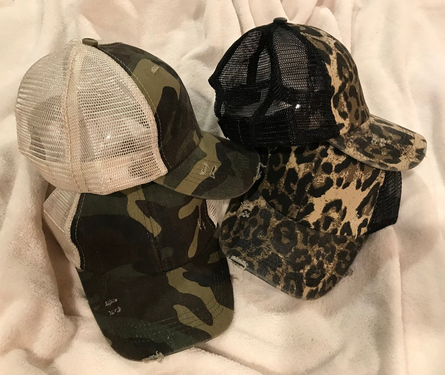 Distressed Baseball Cap in green camo w/ cream mesh or leopard print w/ black mesh w/ distressed bill/adjustable Velcro back.