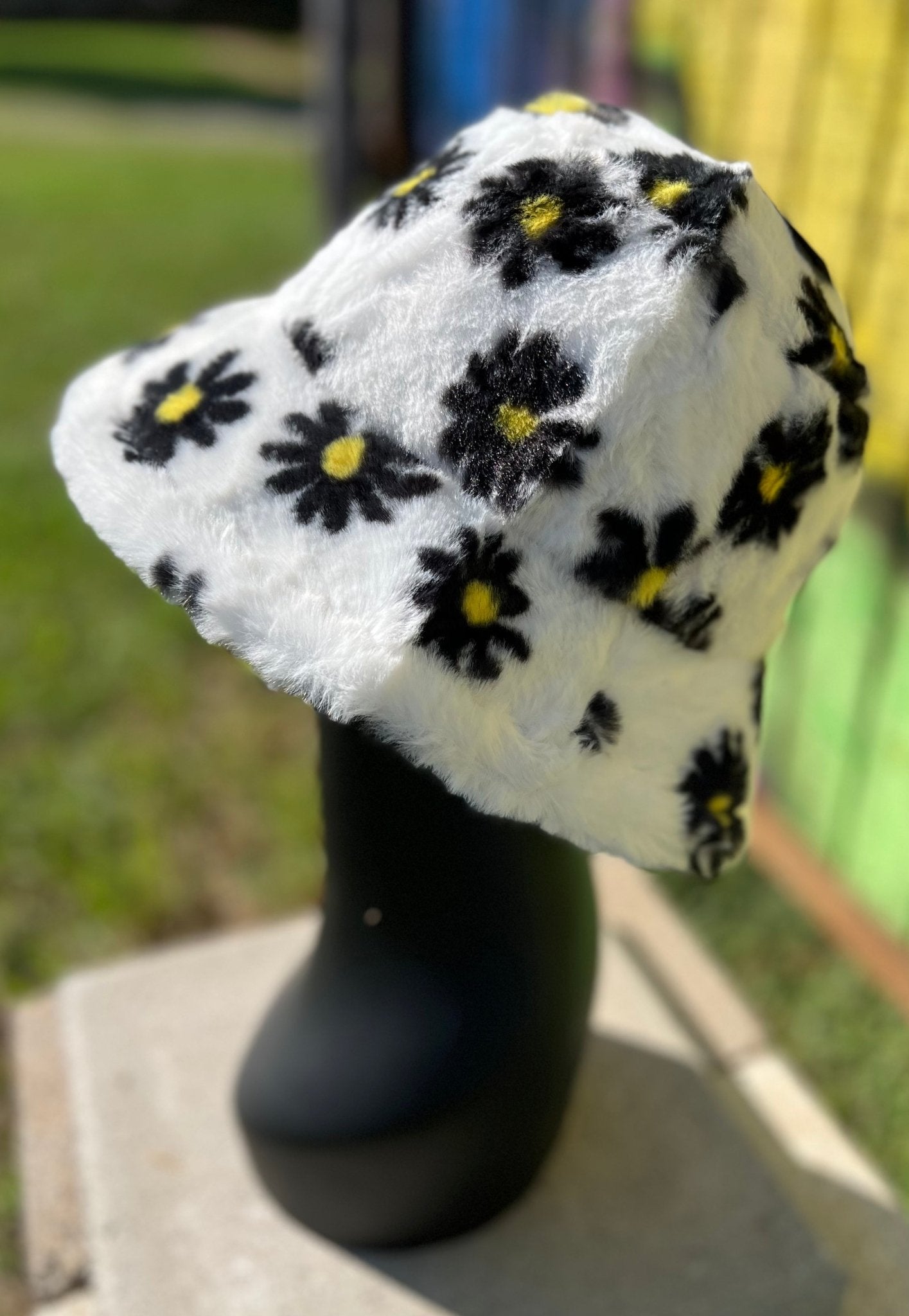 Hana brand. Floral faux fur bucket hat is white with black and yellow flowers and is 100% polyester. One size. $15