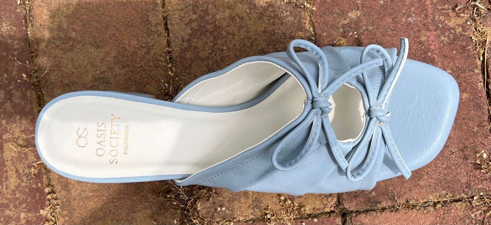 Light blue double bow peep hole sandal with low heel and slip-on design. Vegan leather with DreamCloud cushion.