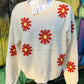 Relaxed fit boucle fabric floral knit cropped sweater is adorned w/ red and yellow flowers. Crew neck & long sleeves.