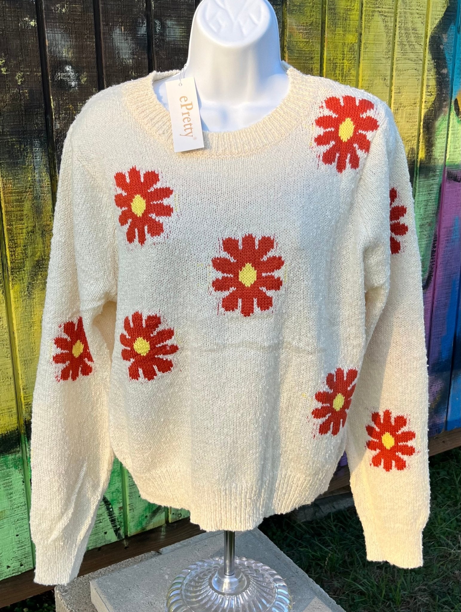 Relaxed fit boucle fabric floral knit cropped sweater is adorned w/ red and yellow flowers. Crew neck & long sleeves.