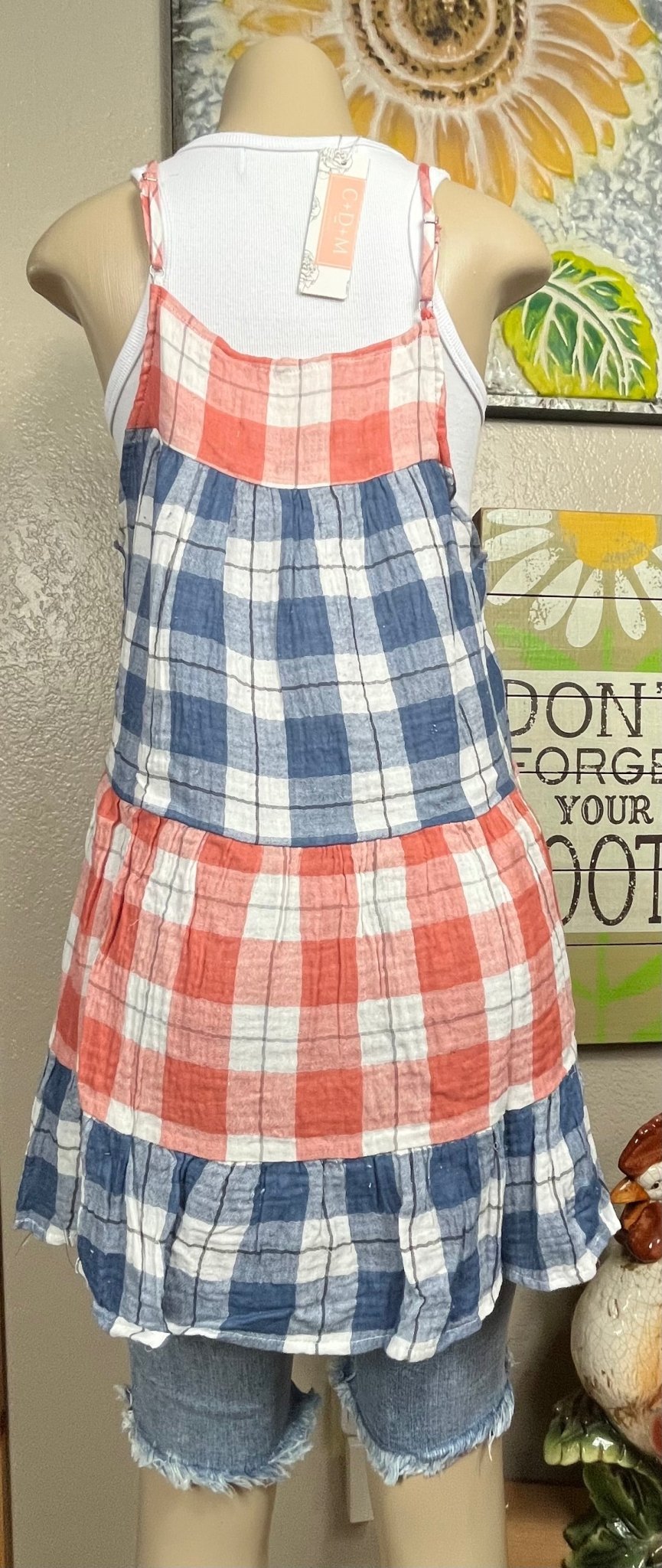 This red & blue denim checkered plaid baby doll top is tiered with a ruffled hem. Actual color may vary from images shown.