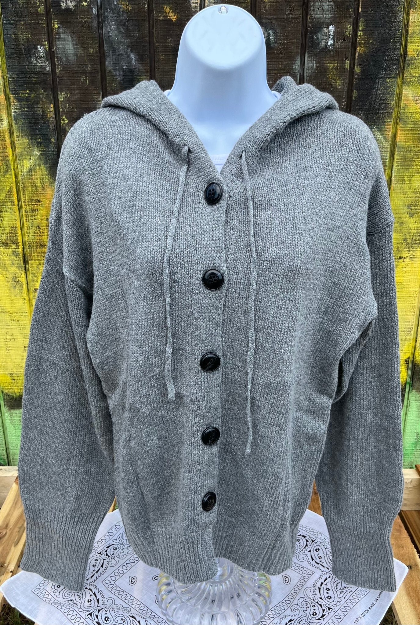 Button front hooded cardigan with adjustable drawstrings and ribbed cuffs is available in classic black, grey or off white.