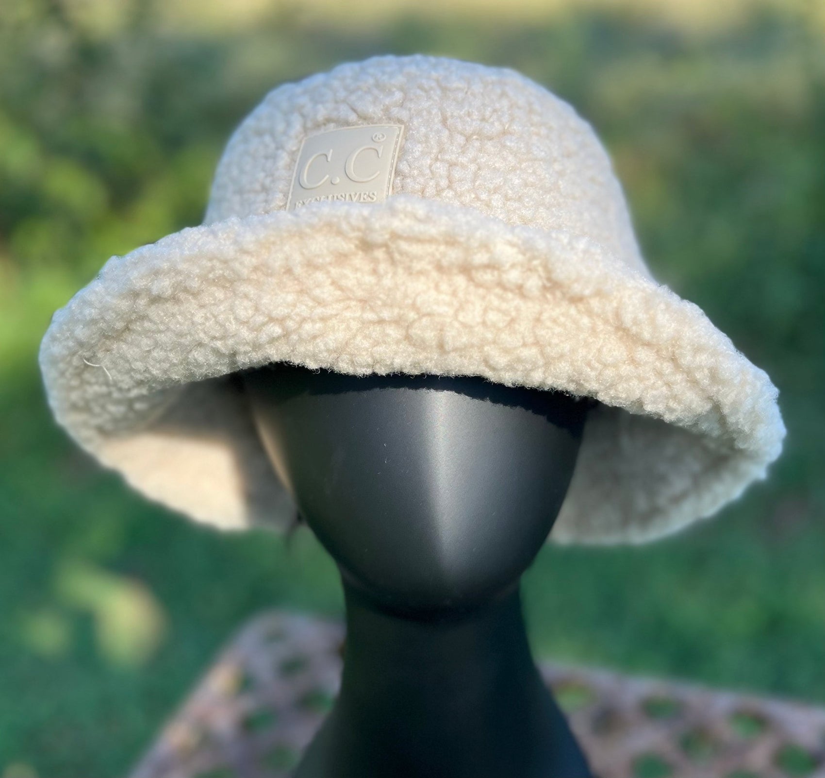 Hana brand. The C.C rubber patch bucket hat is 100% faux sherpa and is available in beige or classic black. One size. $20