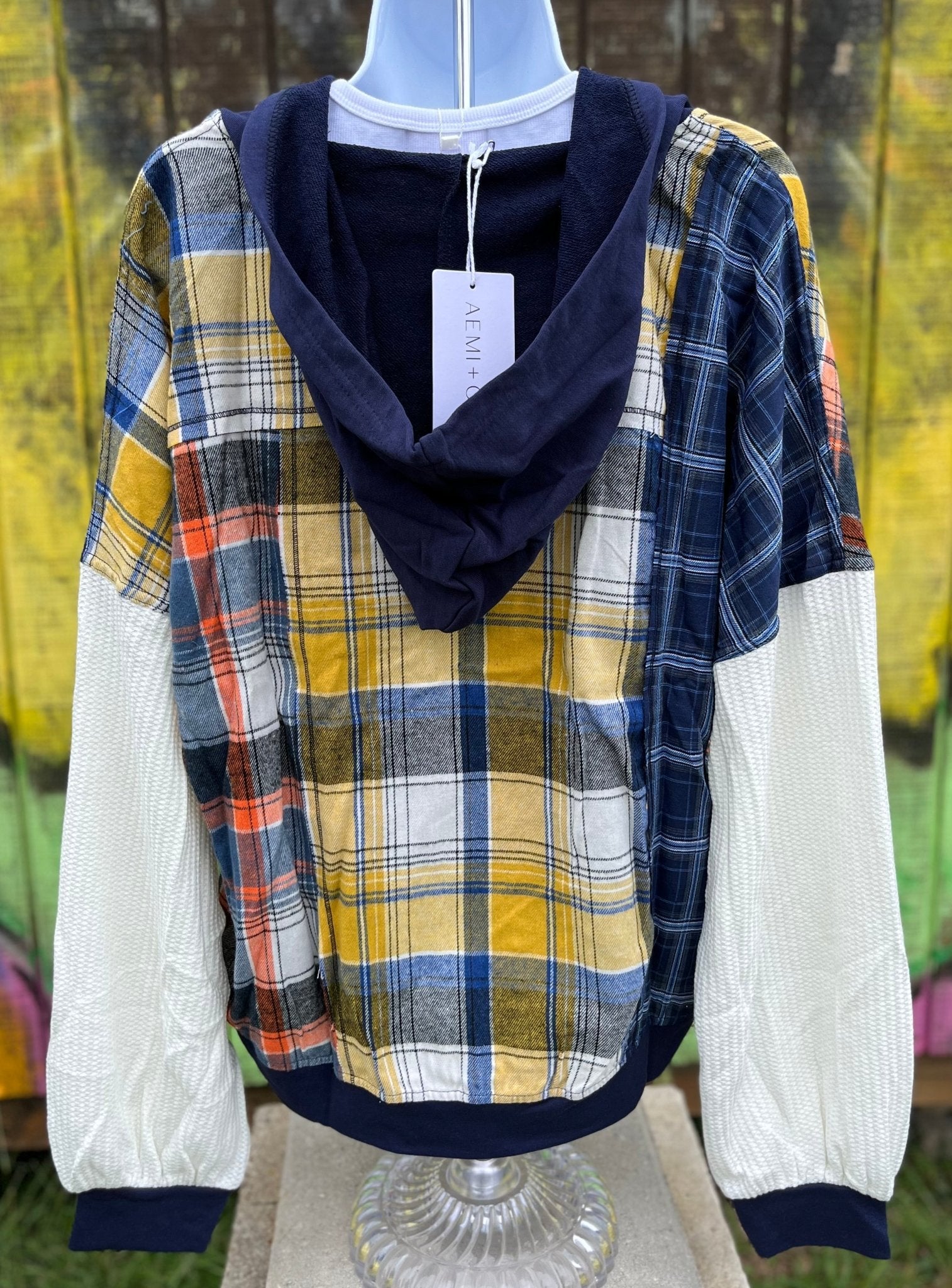 Features multicolored contrast patchwork flannel w/ waffle knit sleeves & banded navy opening w/ matching zipper & hood.