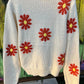 Relaxed fit boucle fabric floral knit cropped sweater is adorned w/ red and yellow flowers. Crew neck & long sleeves.