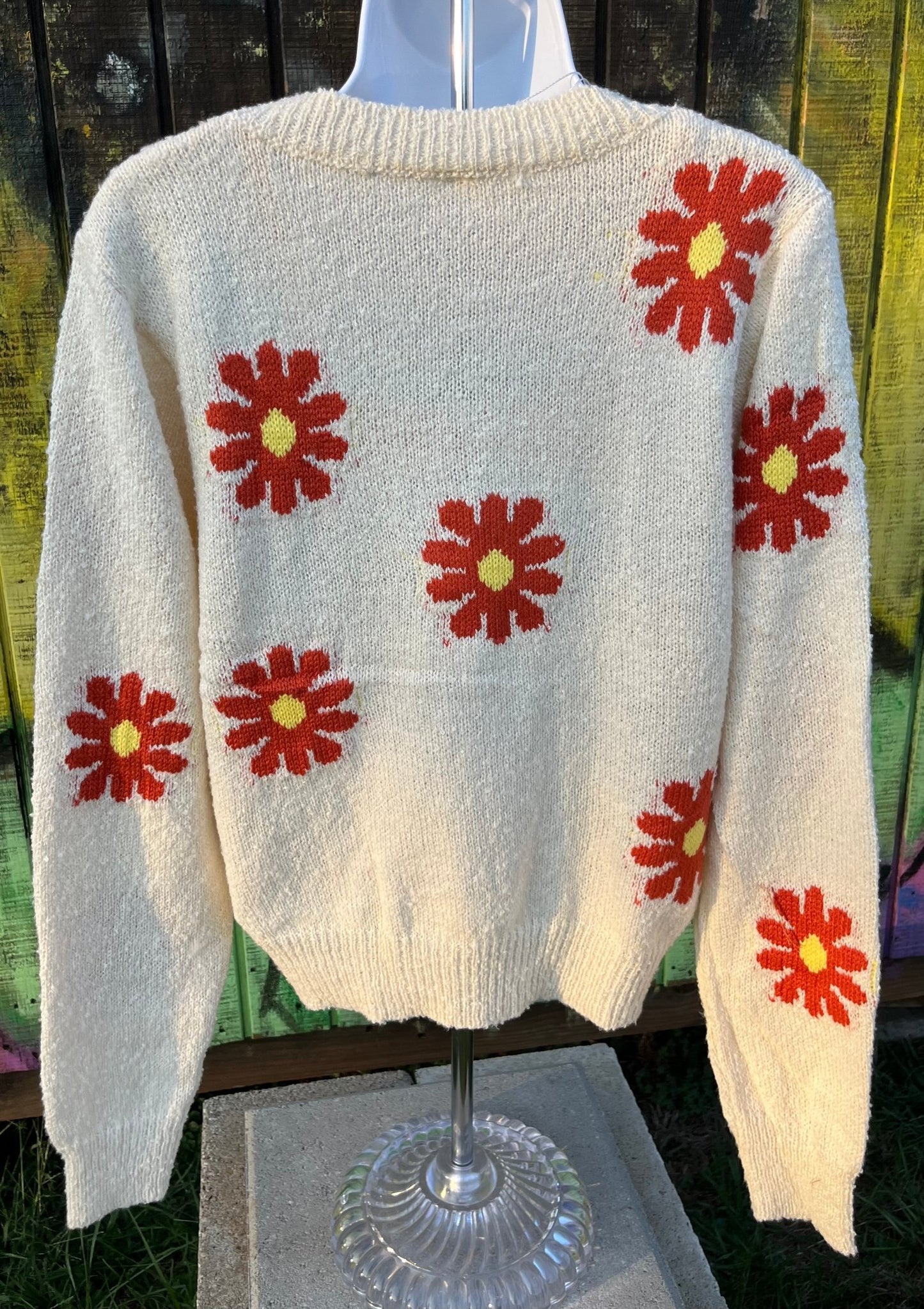 Relaxed fit boucle fabric floral knit cropped sweater is adorned w/ red and yellow flowers. Crew neck & long sleeves.