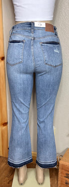 Judy Blue brand. Mid rise, release hem, cropped bootcut jean has front pocket distressed accent.