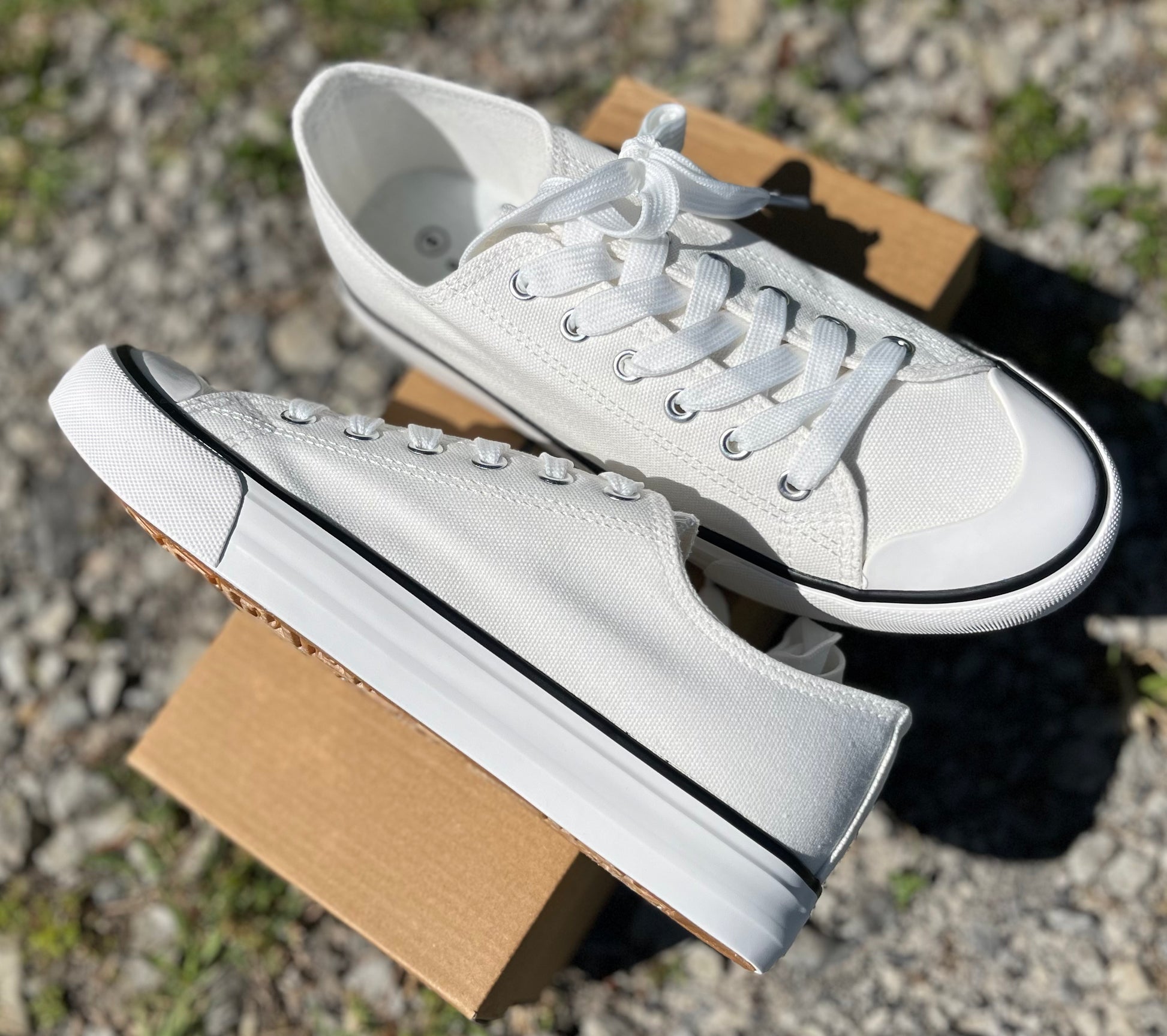 Classic Sneakers in white or beige lace up canvas w/ durable rubber toe & sole with a black outline.