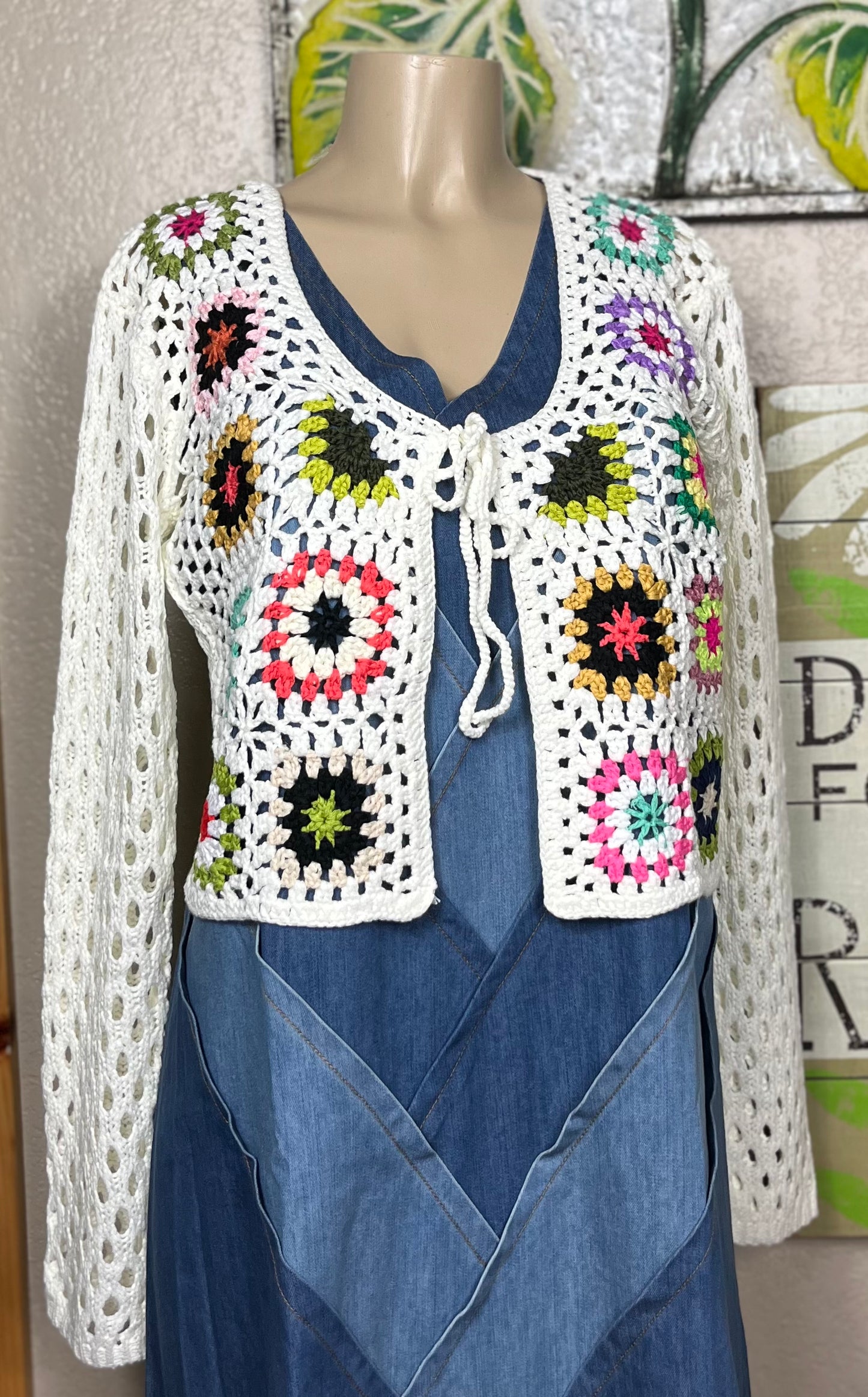 ADORA LA brand. This front tie crocheted cardigan is available in black or cream. Randomly sewn multicolored granny squares.