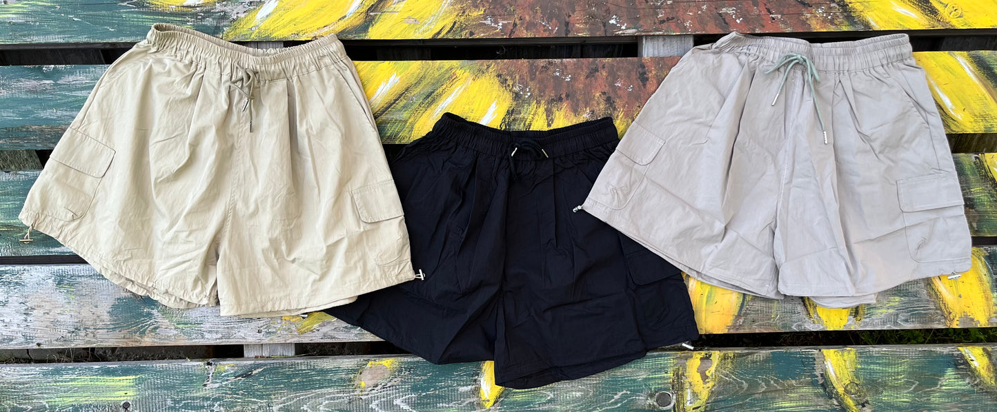 ADORA LA brand. Wide leg cargo shorts in khaki, black and gray. Lightweight with elastic drawstring waist and wide legs.