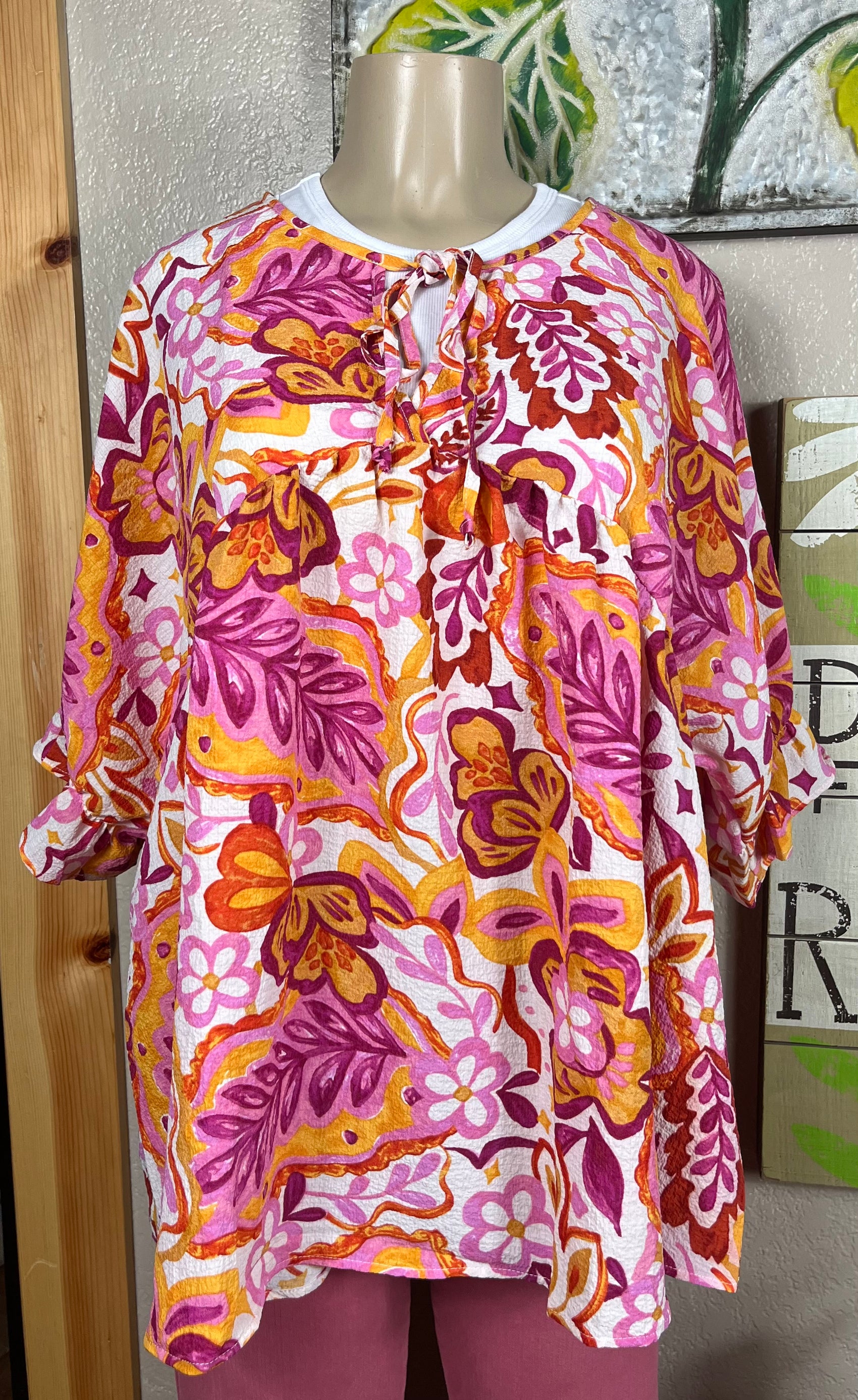 ADORA LA brand. Plus size peasant floral top with front tie detail, ruffled puff sleeve in hot pink, orange and white.