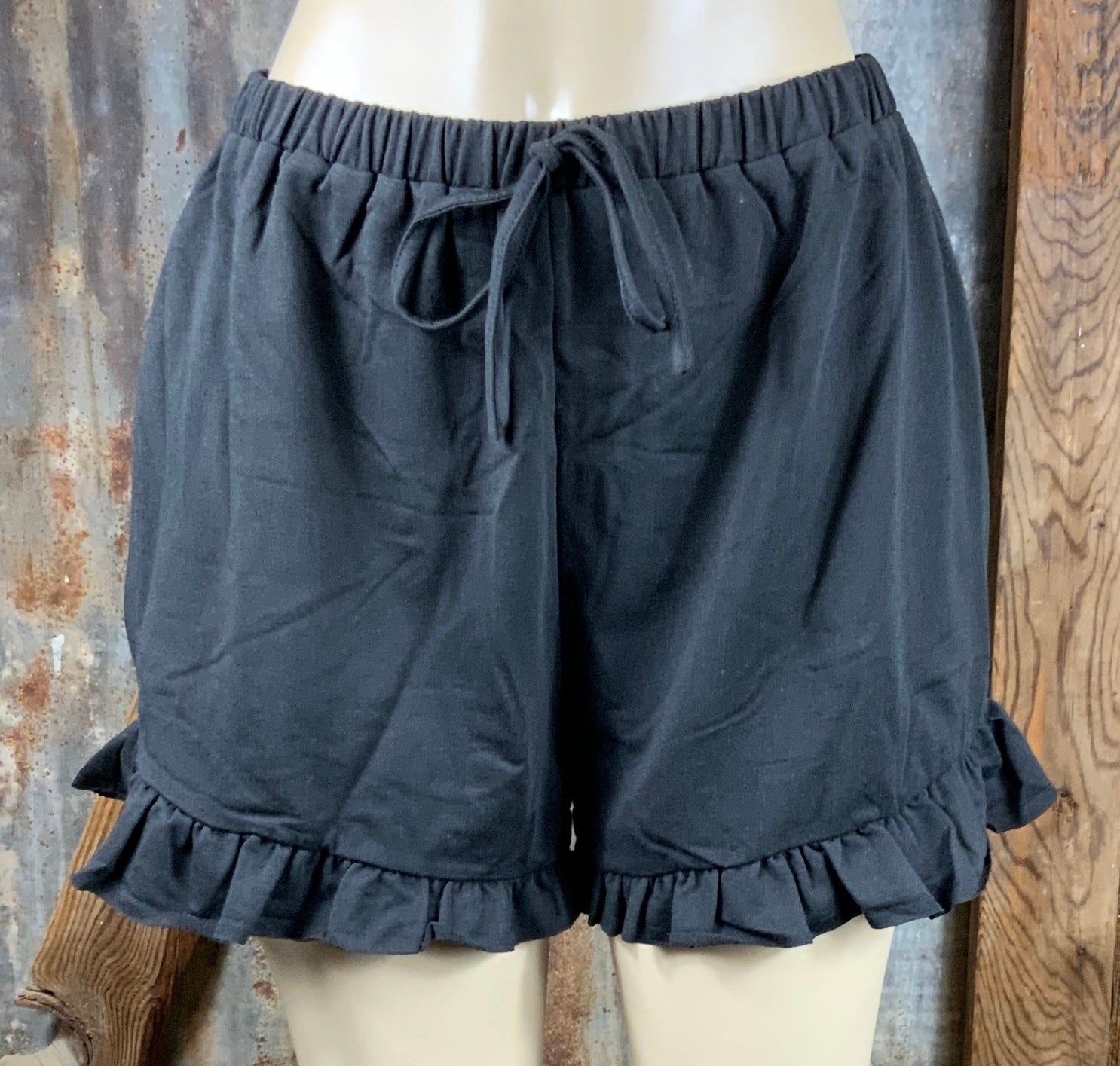 Main Strip brand. Drawstring tie waisted shorts with ruffled bottom hem. Loose fit. Available in Dusty Rose and Black.