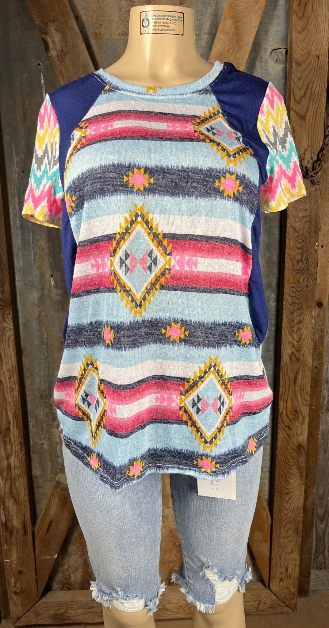 Celeste Clothing brand. Aztec and striped design print with navy accents, short sleeves with multicolored chevron pattern.