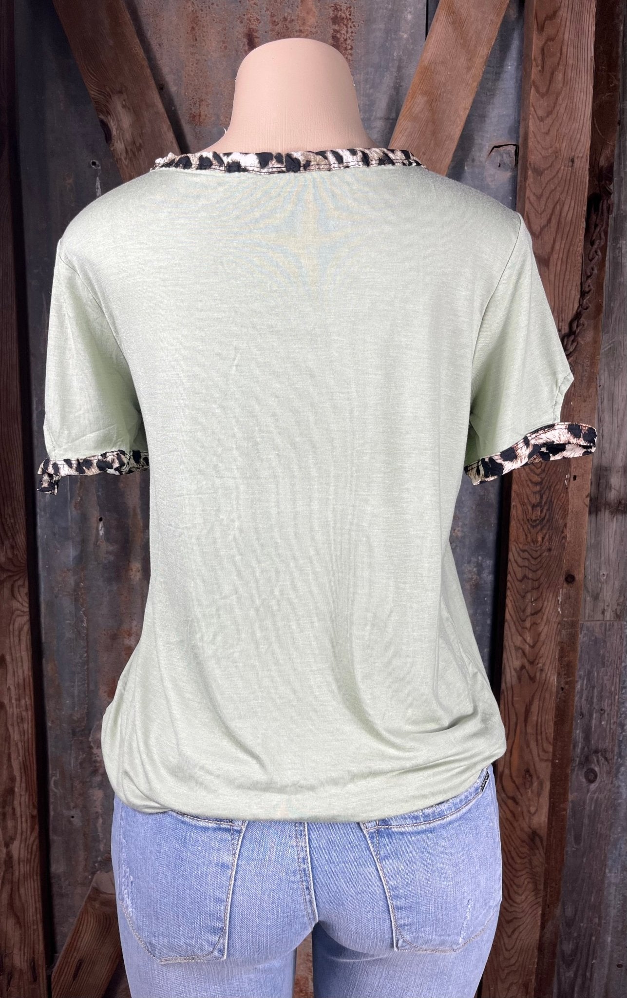 Celeste Clothing brand. Light sage green top with leopard trim cut out detail on neck and sleeves. S, M, L, XL. $15