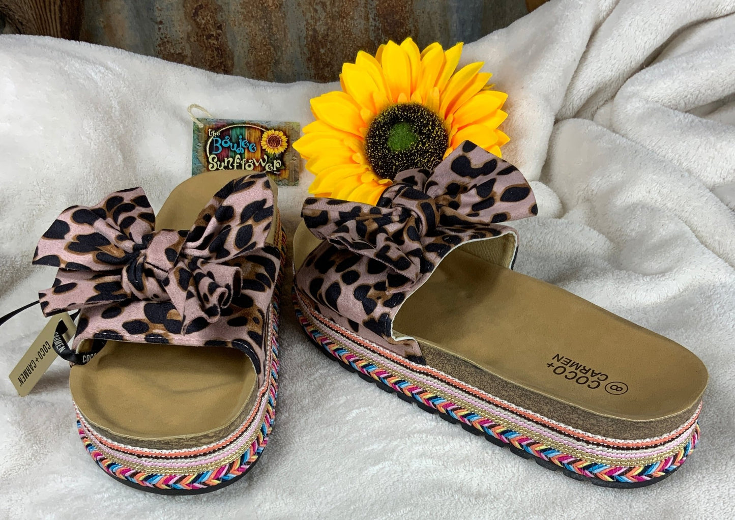 Single wide leopard strap adorned with leopard bow. Cork base featuring colorful threaded design and durable rubber sole.