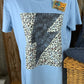 ESLEY brand. Tee available in light blue, white or peach with black lightning bolt and leopard design. S, M, L, XL. $10