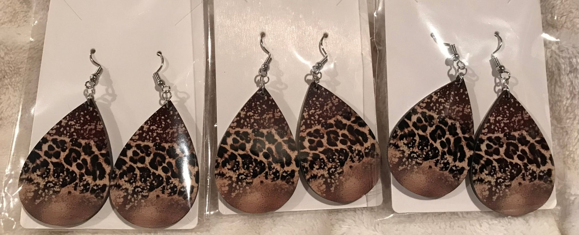 Earring Babe Boutique brand. 2.5" hard material, silver dangle with leopard and speckled print design. $7.25