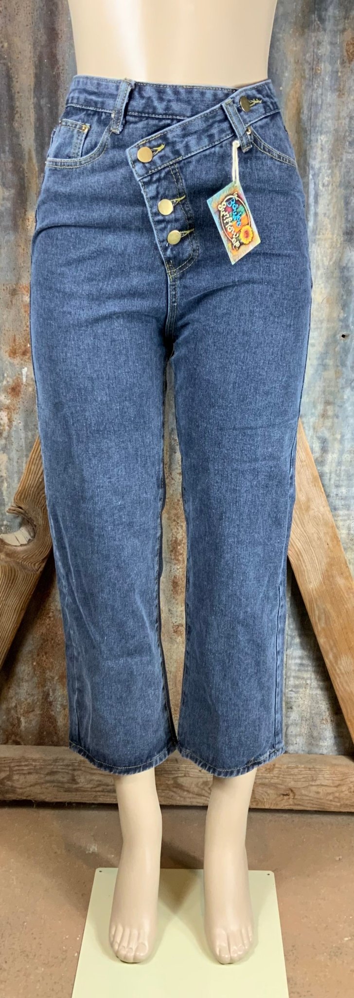 Vintage-inspired high waisted jeans with asymmetrical button closure. Straight legs are slightly tapered at the ankles.