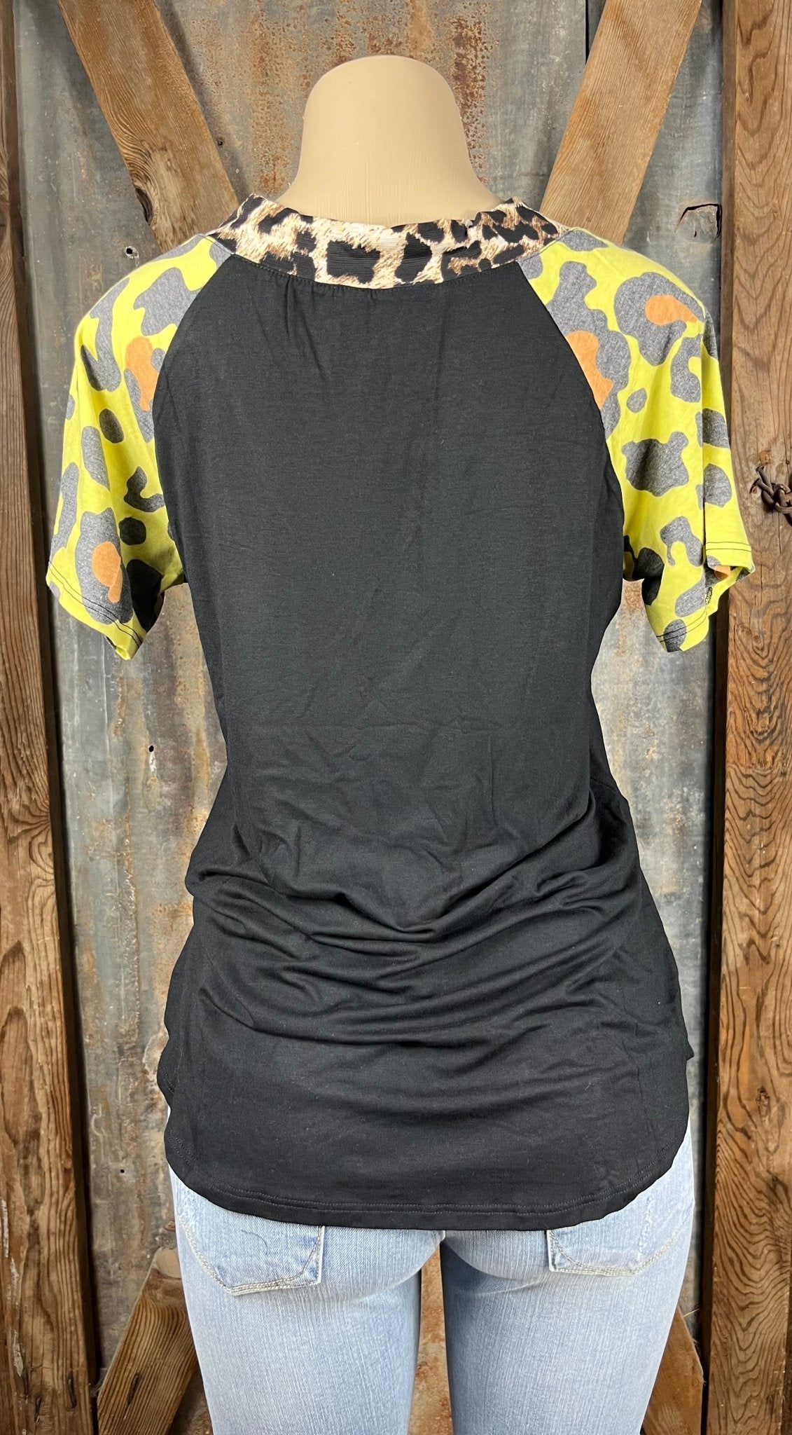 All That Sass! Women's Top Classic Leopard v-neck with black bodice and yellow short sleeves accented with orange and gray leopard.