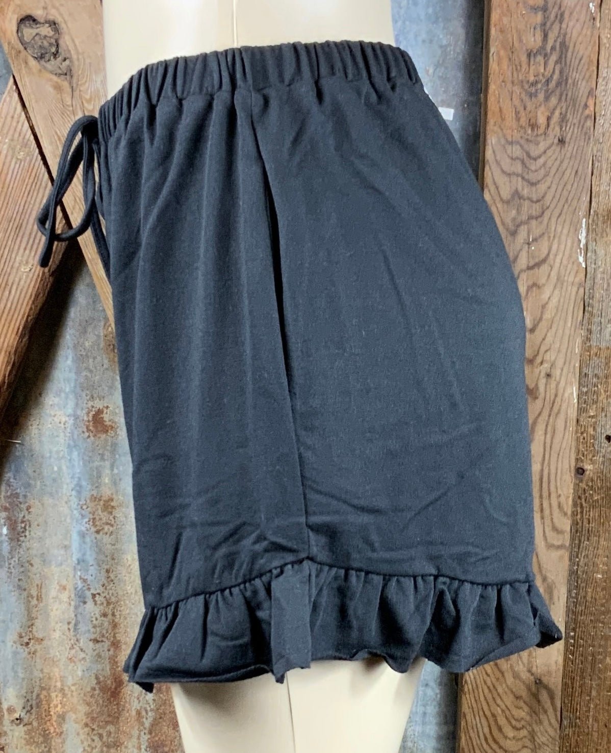 Main Strip brand. Drawstring tie waisted shorts with ruffled bottom hem. Loose fit. Available in Dusty Rose and Black.