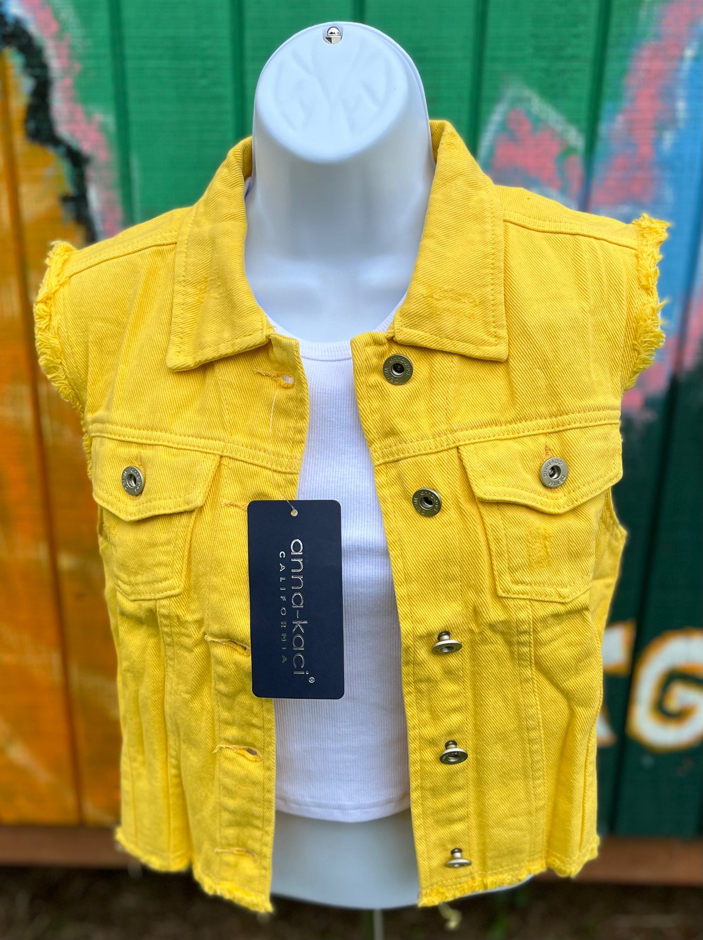 Anna Kaci brand. Yellow denim vest with metal buttons and frayed design. It is sleeveless and cropped. 100% cotton. S, M, L, XL, 2X. $38