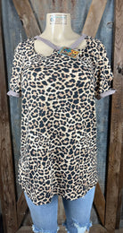 Celeste Clothing brand. Leopard print top with longer length and asymmetric cut out holes in beige trim on neck and sleeves.