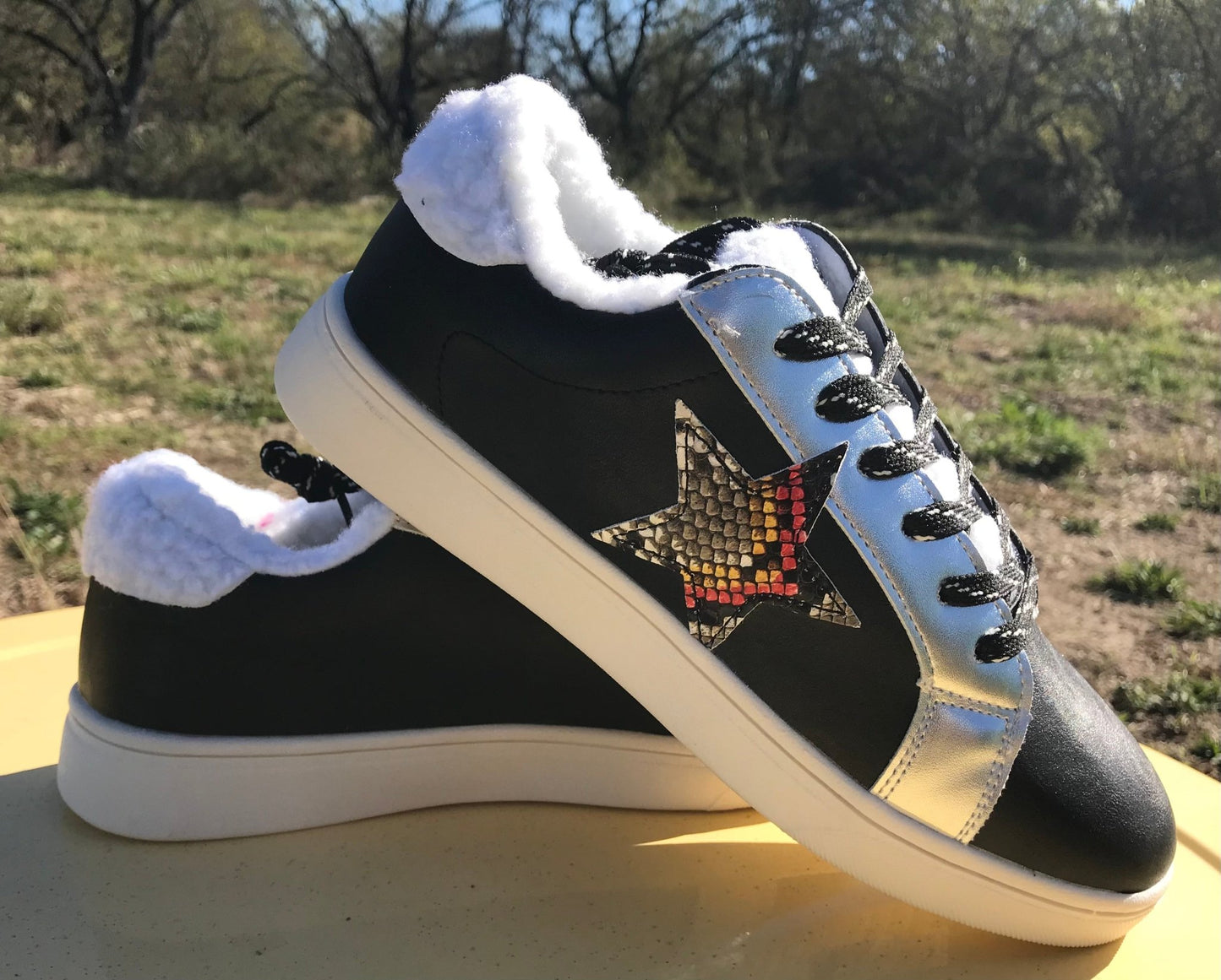 Black shoes with silver metallic, multicolored snakeskin star accents. Faux sherpa interior lining, tongue and outside heel.