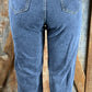 Vintage-inspired high waisted jeans with asymmetrical button closure. Straight legs are slightly tapered at the ankles.