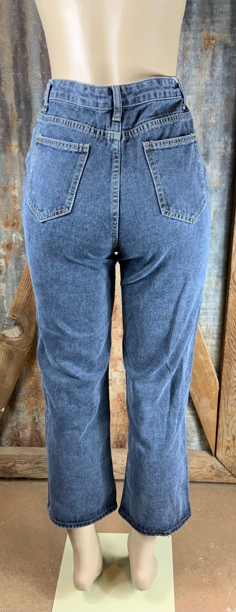 Vintage-inspired high waisted jeans with asymmetrical button closure. Straight legs are slightly tapered at the ankles.