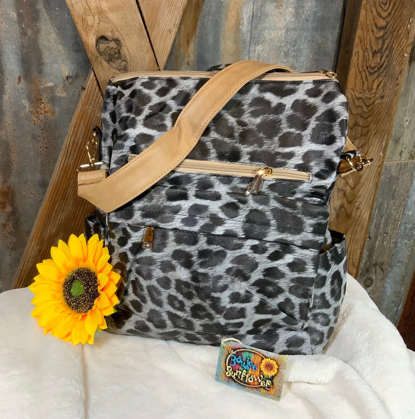 LivFoxy brand. Gray leopard backpack with strap and zippered outer pockets. Tan accented color. Gold hardware. $25