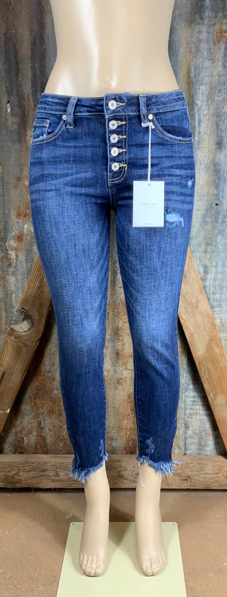 KanCan brand. These true to size fit jeans have a button fly with high rise ankle, distressed accents and frayed hems.