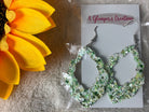 A Glamper's Creations, LLC brand. These scalloped leather earrings are accented in green, white and gold glitter. $10