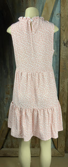 ESLEY. This blush colored white floral, lightweight unlined woven fabric is sleeveless w/ tiered design & ruffled collar.