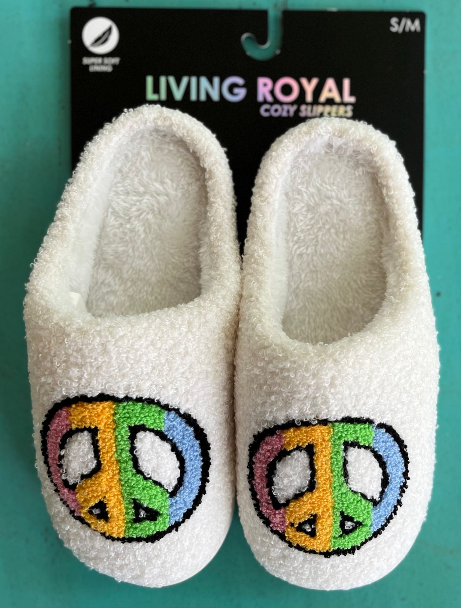 Living Royal brand. These slippers feature white soft interior and exterior material, colorful peace sign and white hard rubbler soles for indoor/outdoor wear. S/M fits a women's 5-8. M/L fits a women's 9-12. Unisex. 100% polyester. Machine washable. $22