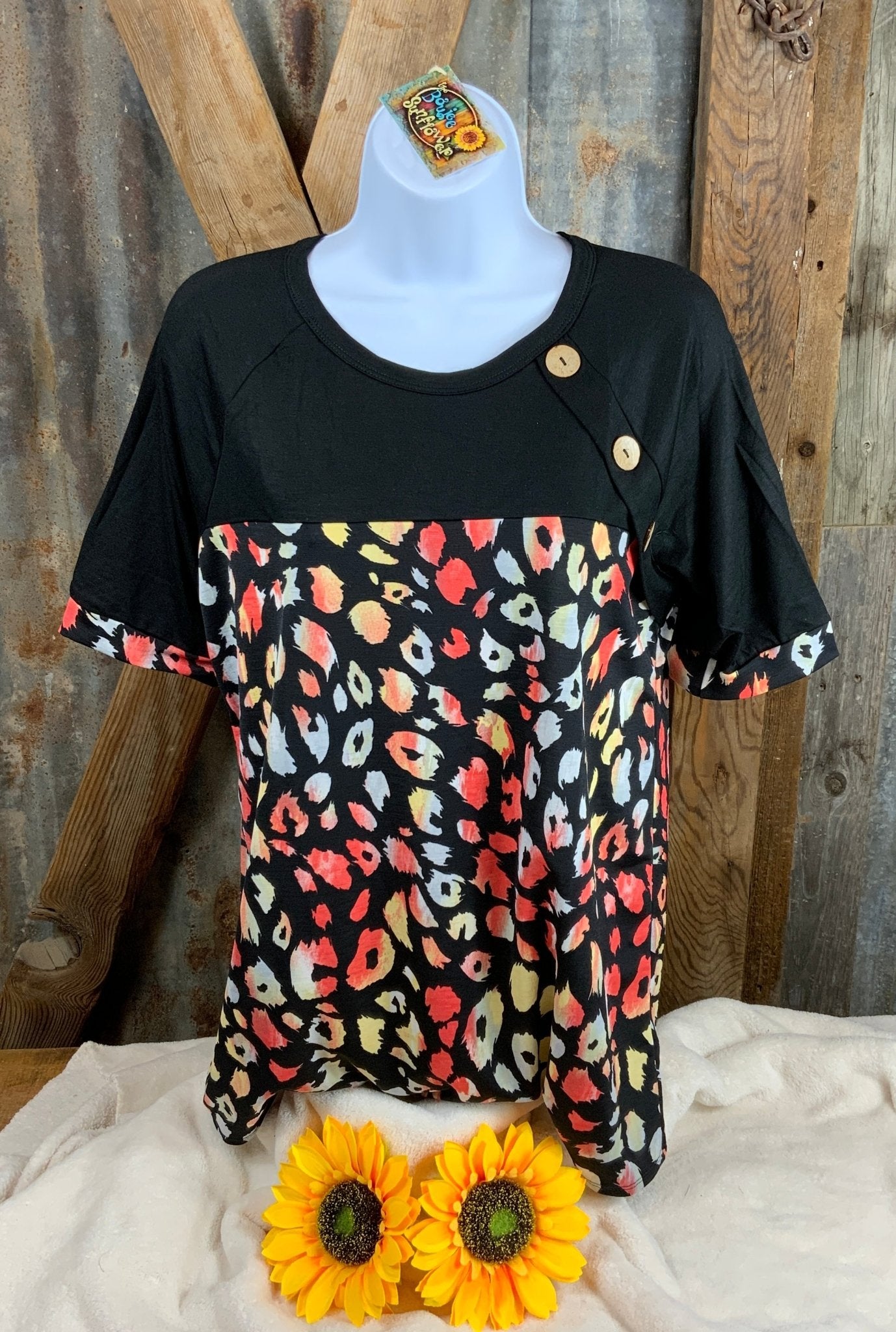 Celeste Clothing brand. This raglen contrast top has black and colorful leopard print and button accents. M, L $16