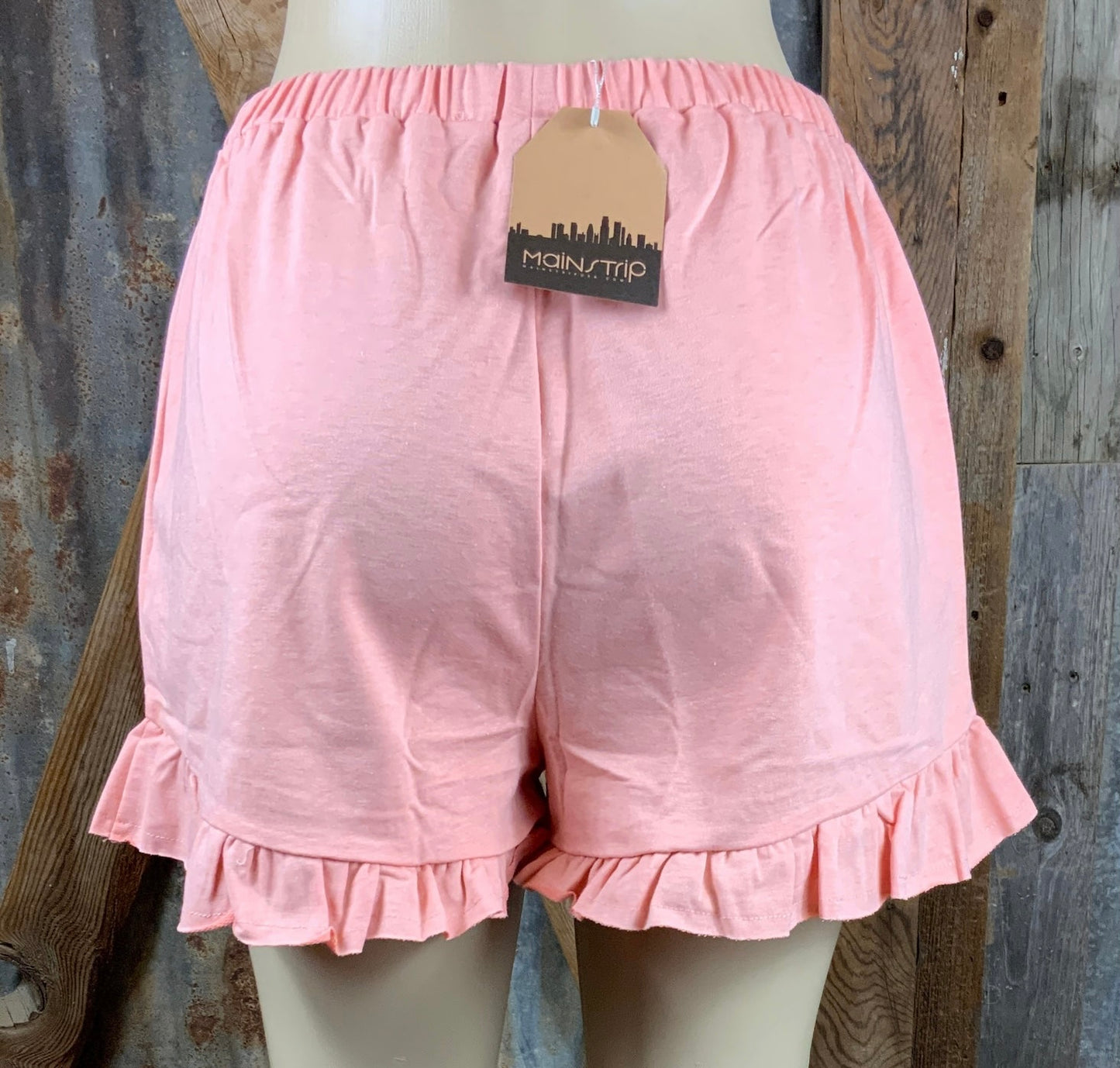 Main Strip brand. Drawstring tie waisted shorts with ruffled bottom hem. Loose fit. Available in Dusty Rose and Black.