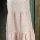 ESLEY. This blush colored white floral, lightweight unlined woven fabric is sleeveless w/ tiered design & ruffled collar.