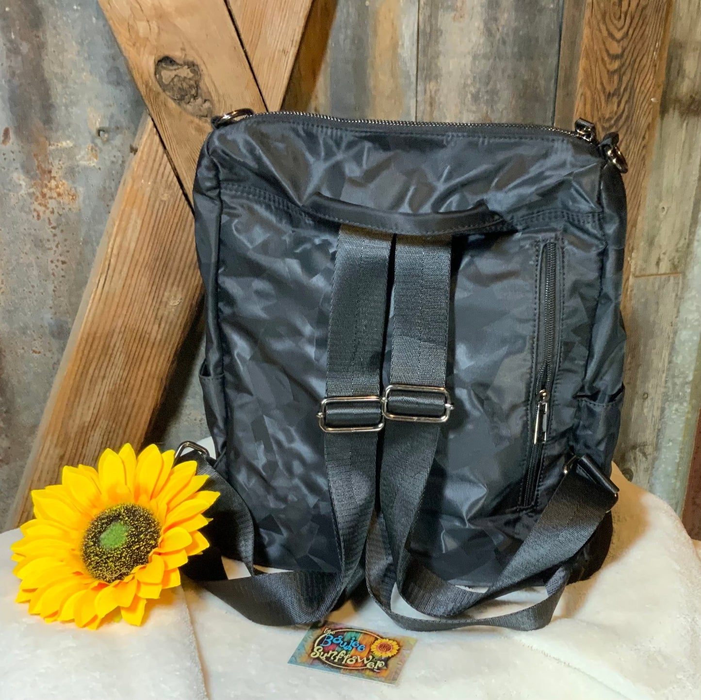 This lightweight backpack in camo or black has a roomy interior and zippered outside pouch. Bag measures 15" x 10" x 5".