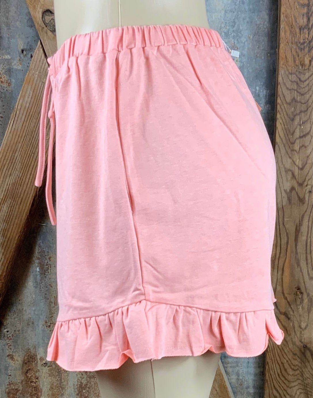 Main Strip brand. Drawstring tie waisted shorts with ruffled bottom hem. Loose fit. Available in Dusty Rose and Black.