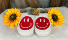 White fluffy exterior with red happy face, beige soft interior with white hard rubber sole for indoor/outdoor wear.