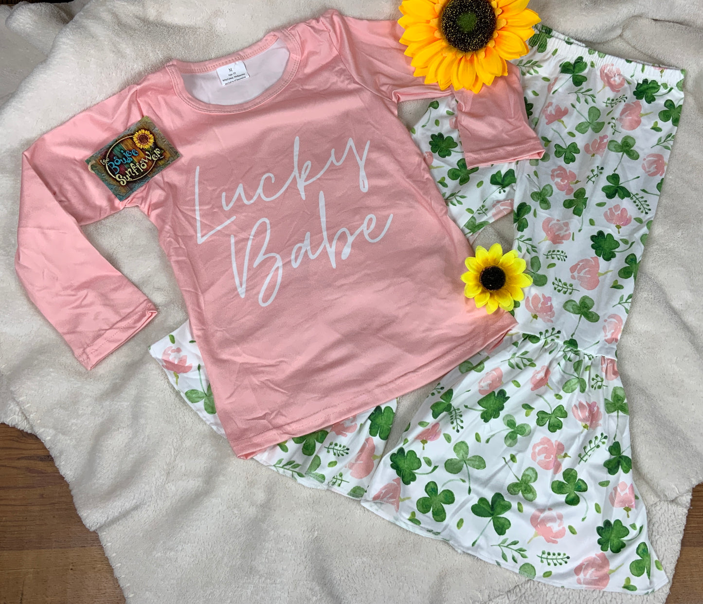 Yawoo Garments brand. Toddler set. Blush long sleeved tee with "Lucky Babe" in white and elastic waist leggings with green shamrocks and blush roses with bell bottoms. 2T, 3T, 4T. $15